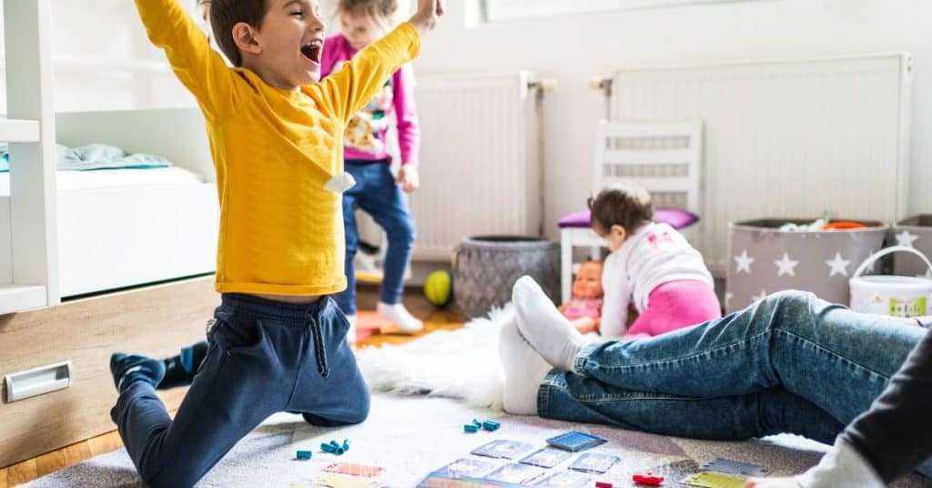 Boy in yellow shirt winning family game night. 