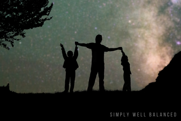 The shadow of a father and kids having fun at night doing an outside hike to look at stars. 