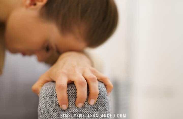 Overwhelmed mom with her head resting on her arm.