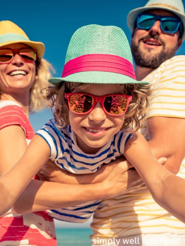 Family having summer fun, wearing brightly colored shirts, hats and sunglasses. 