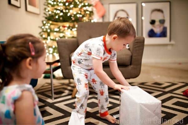 Toddler opening Christmas gift.